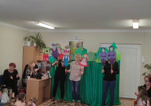 Aktorzy- nauczyciele prezentują się z sylwetami postaci z baśni poetyckiej pt. " Na jagody".